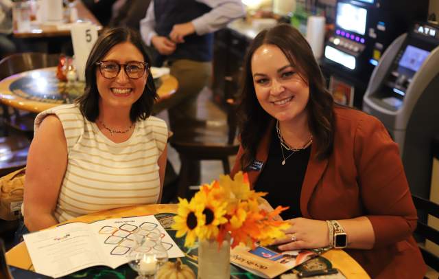 Two friends smiling at an event.