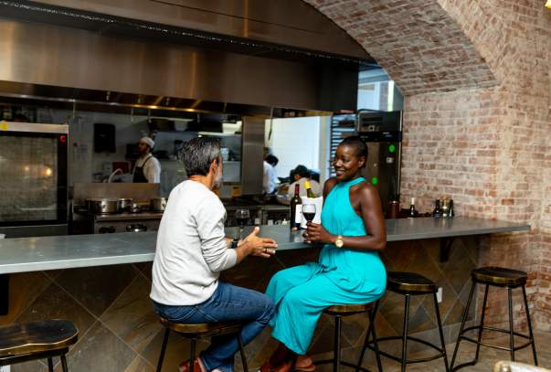 A couple sits together enjoying a cocktail.