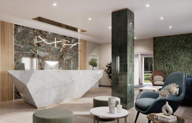 Chic hotel lobby with a marble counter, green accents, and modern chairs.