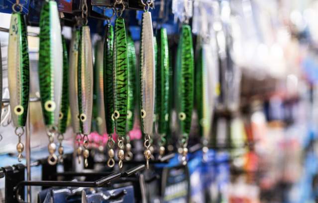 Green fishing lures hang on a shop wall