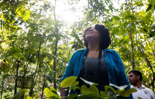 Tourist crossing the Las Tablitas trail surrounded by leafy trees