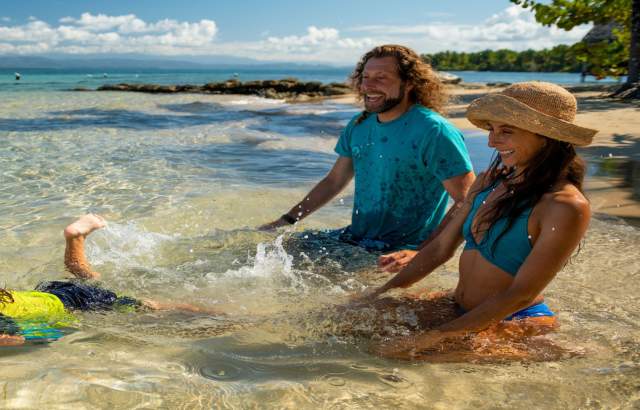 A family enjoy on the shore of the beach in a sunny day