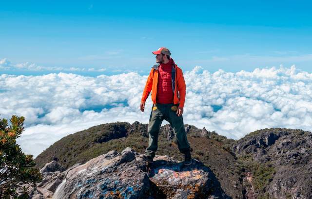 Man standing on a mountain summit above the clouds in Tierras Altas, Chiriqui
