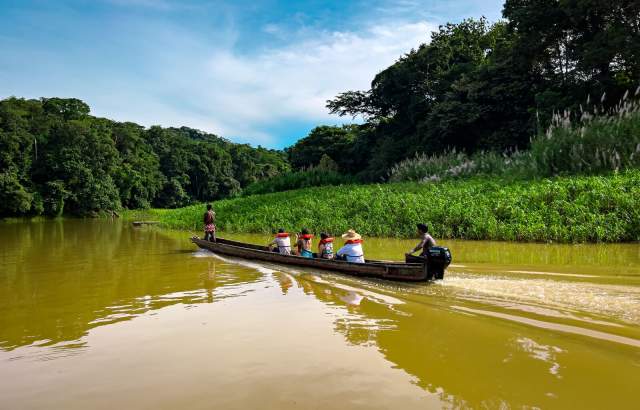 Comunidade Emberá-Wounaan navegando em piragua por um rio na selva do Panamá