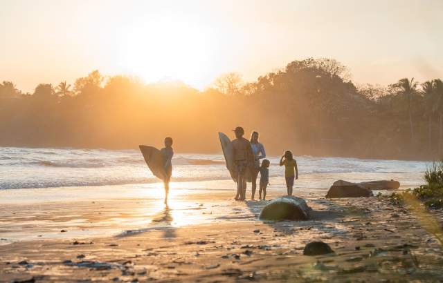 Sunrise view of surfers walking on the coast of Estero Beach at Santa Catalina