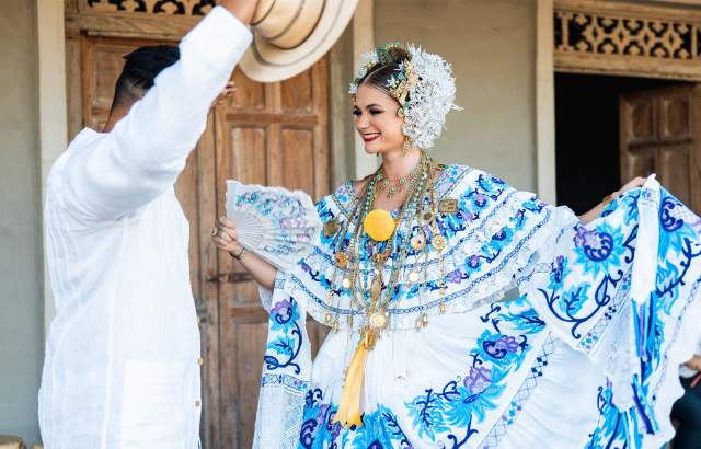 Dressed with typical panamanian clothes Pollera de Gala white fabric with blue embroider blue flowers