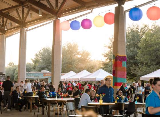 Attendees at the DHL Now & Next Logistics Summit enjoy an evening event on the patio at the Palmer Event Center with food trucks
