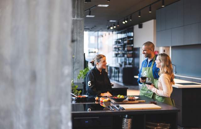 2 people drinking wine with chef at a cookery class, Manchester