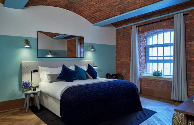 Hotel bedroom with exposed brickwork and large bed