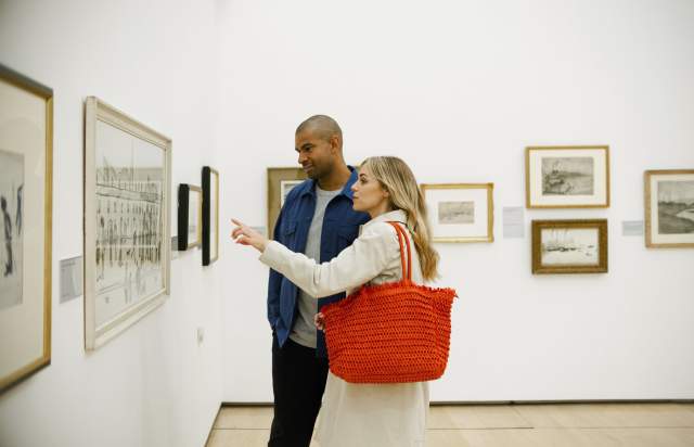 2 people in art gallery looking at photo