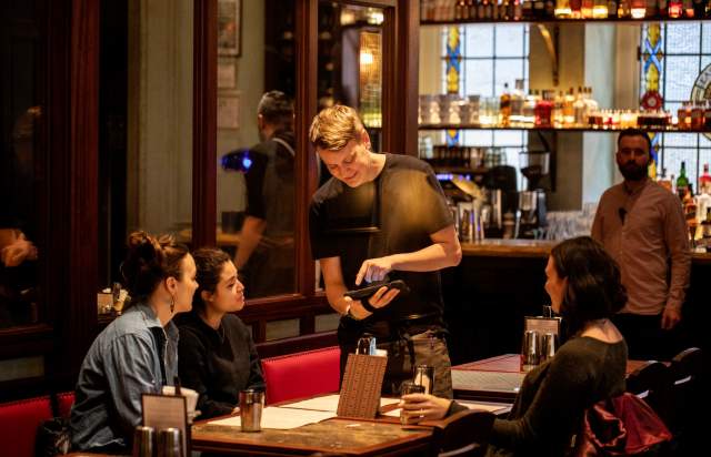 Server at restaurant serving a table