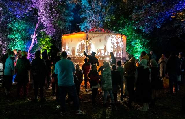 Crowd of families watching show outdoors with lighting