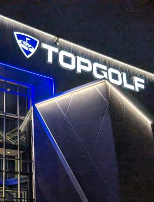 Topgolf Woodbury in the evening showing the building lights