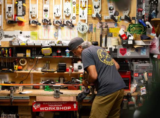 Darryl Tatom, Owner of Small Planet in workshop surrounded by sporting gear