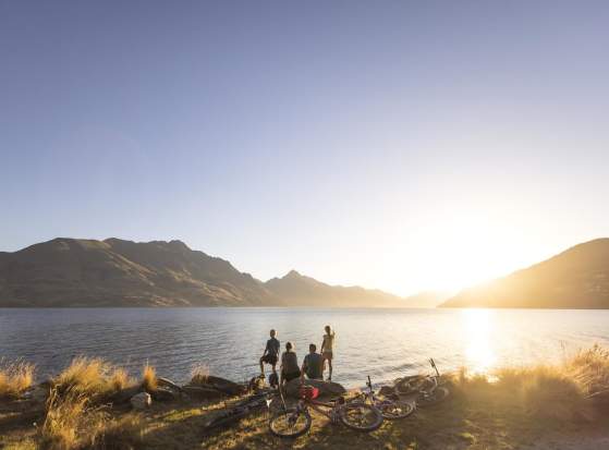 Family with bikes stops to admire views over Lake Whakatipu from Queenstown Gardens