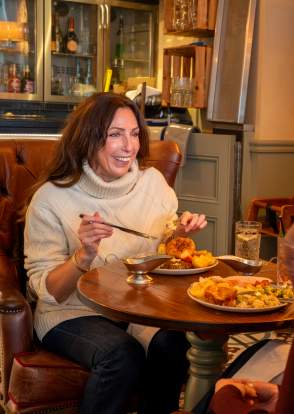 Two ladies enjoy a roast dinner in front of a real fire.
