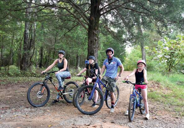 family on bikes in wooded trail