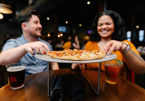 Couple eating pizza at Strawberry Alley