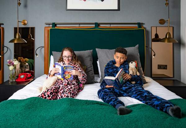 2 children reading in hotel bedroom