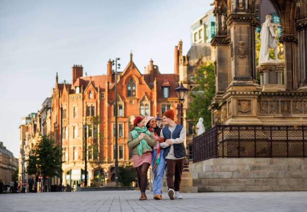 Friends walking across Manchester City Centre