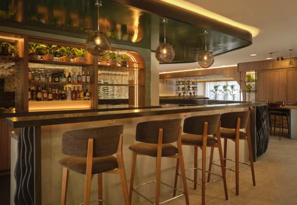 Hotel bar set up with seating and hanging lights