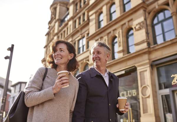 2 people drinking coffee outside