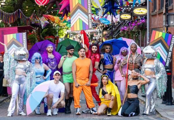 Group of people stood in colourful dress on canal street in Manchester