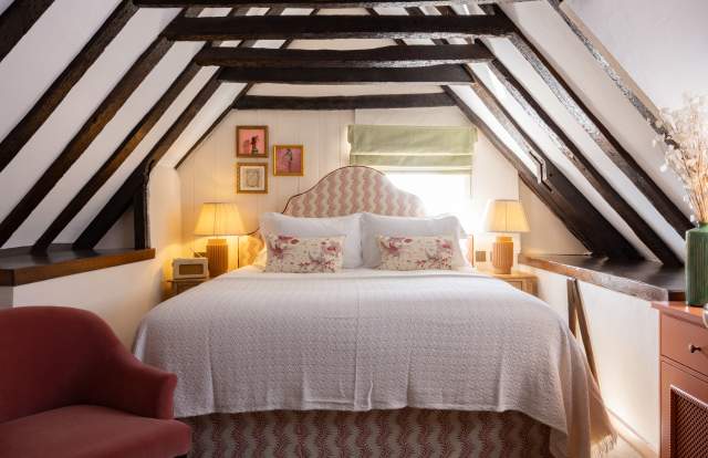 A hotel room with dark beams and a large comfy bed at the White Hart, Lewes