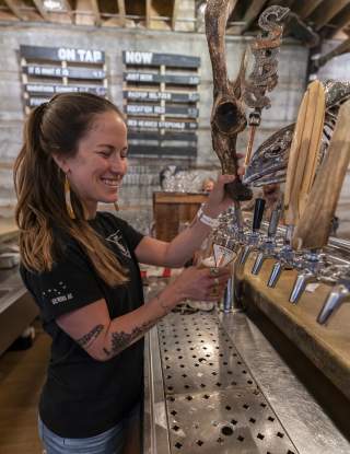 Woman pouring beer at Seward Brewing Company