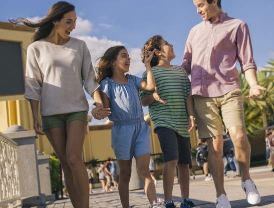 An hispanic family walking in a theme park.
