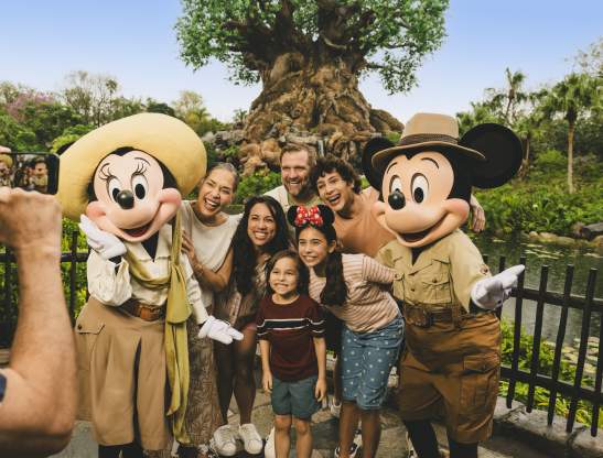 Multi-generational mixed hispanic family with Mickey and Minnie at Animal Kingdom
