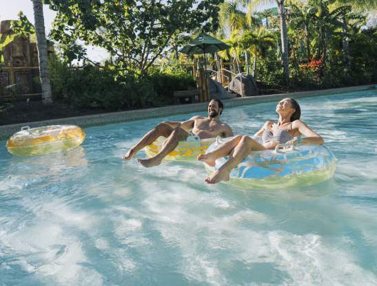 couple floating on innertubes in volcano bay