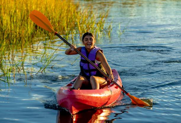 a woman kayaking in the marsh