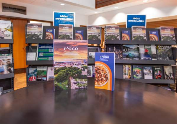 Fargo visitor guide and dining guide in front of brochure racks
