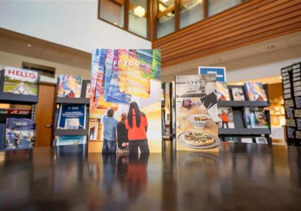 The Visitor Guide and Dining Guide standing upright on a tabletop in teh FM Visitors Center.