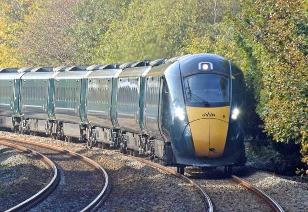 great western railway train on tracks in between trees