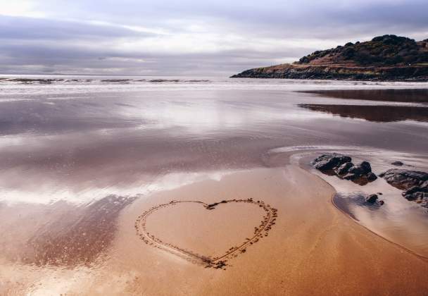 Heart drawn into sand on a beach