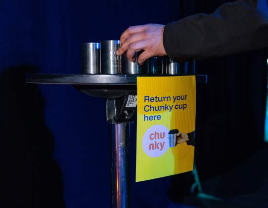 A table at an event filled with reusable chunky coffee cups
