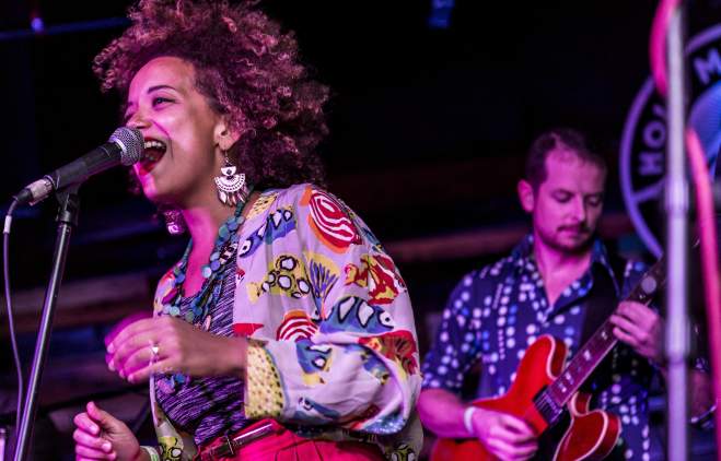 KP & The Boom Boom singer on stage with a guitarist playing behind her