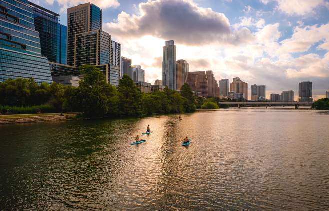 People stand up paddleboarding on Lady Bird Lake.