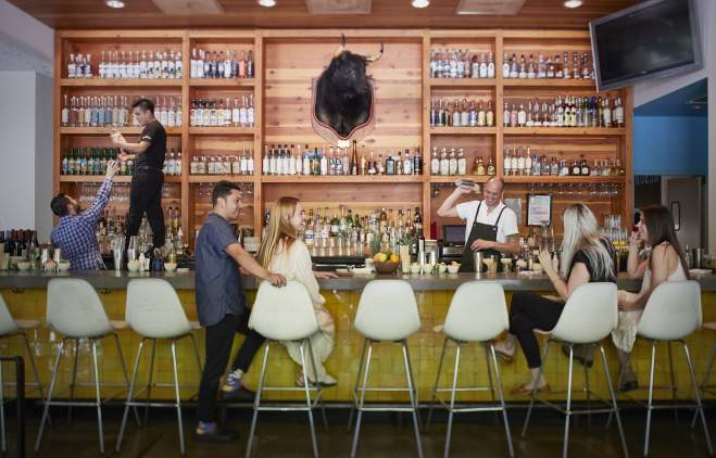 People sitting at bar while bartender shakes cocktail at La Condesa Bar in Austin Texas