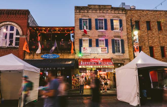 people walking down 6th Street in front of Roppolo's Pizzeria and Shakespeare's Pub in Austin Texas