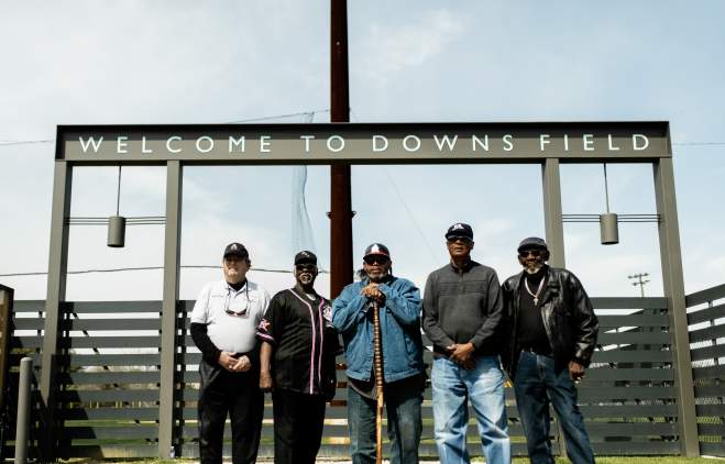 Men gathered under the Downs Field entrance