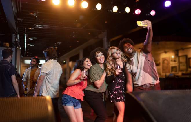 A group of men and women smiling and taking a selfie at Antone's.