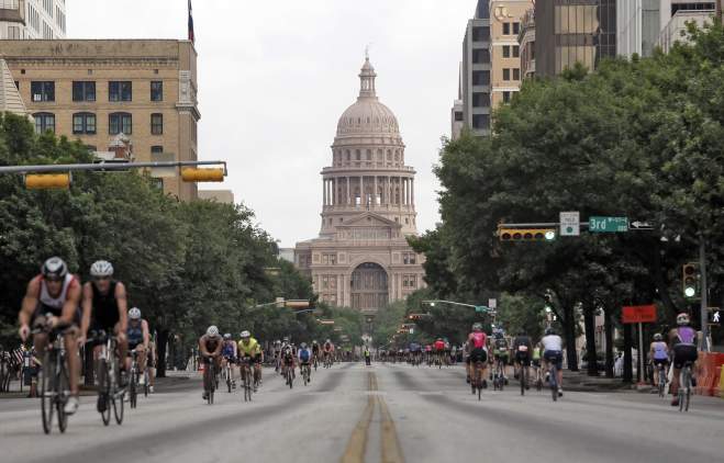 Hundreds of cyclists moving towards and away from the Texas State Capitol on Congress Avenue.