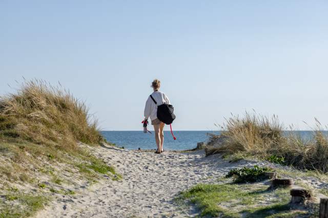 A lone traveller walks to the beach at East Head sand dunes in Sussex