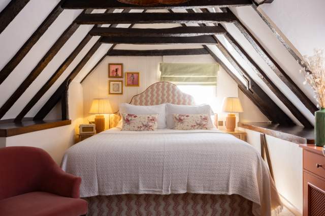 A hotel room with dark beams and a large comfy bed at the White Hart, Lewes