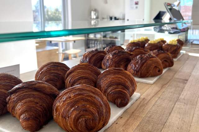 Dozens of freshly baked croissants displayed at Dry Storage Bakery In Boulder, CO