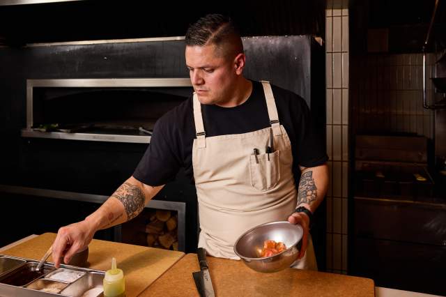 Chef Johnny Curiel seasons food in the kitchen at Cozobi Fonda Fina in Boulder, CO.