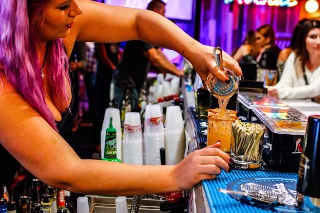 Tin Roof bartender pouring drink